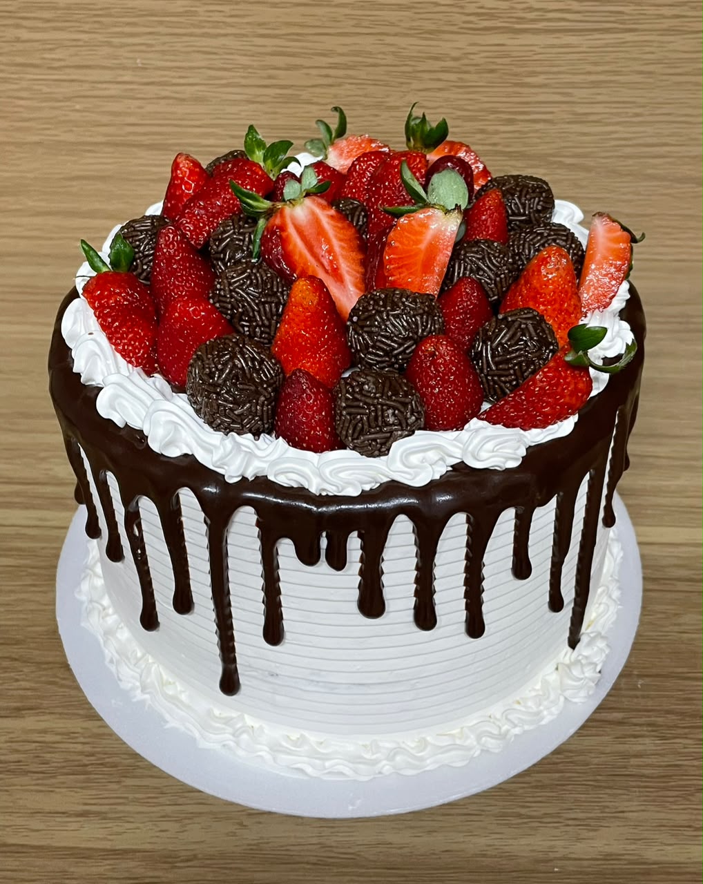 Bolo branco artesanal com drip de chocolate, morangos e brigadeiros gourmet da Nah Vieira Confeitaria